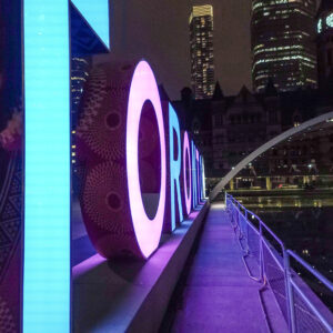 3D Toronto sign lit purple and blue at night. Picture taken at sharp angle.