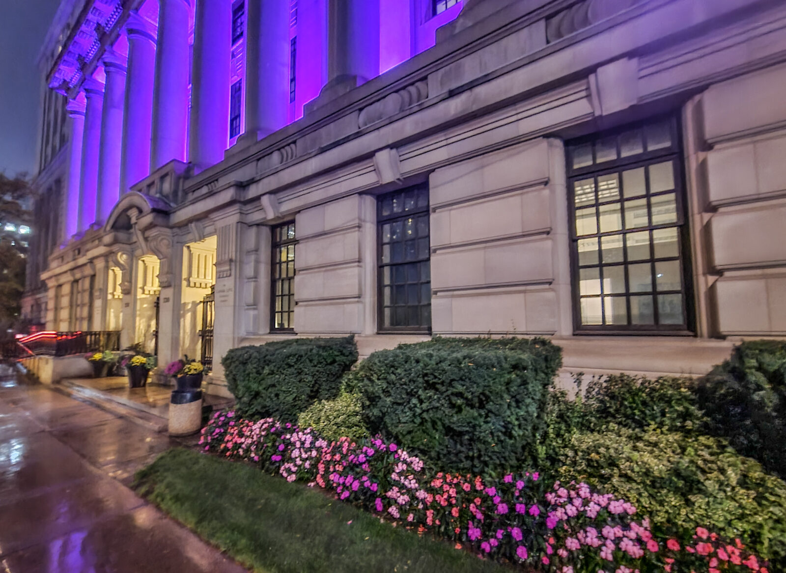 Columns of the Canada Life Building in Toronto, glowing purple.
