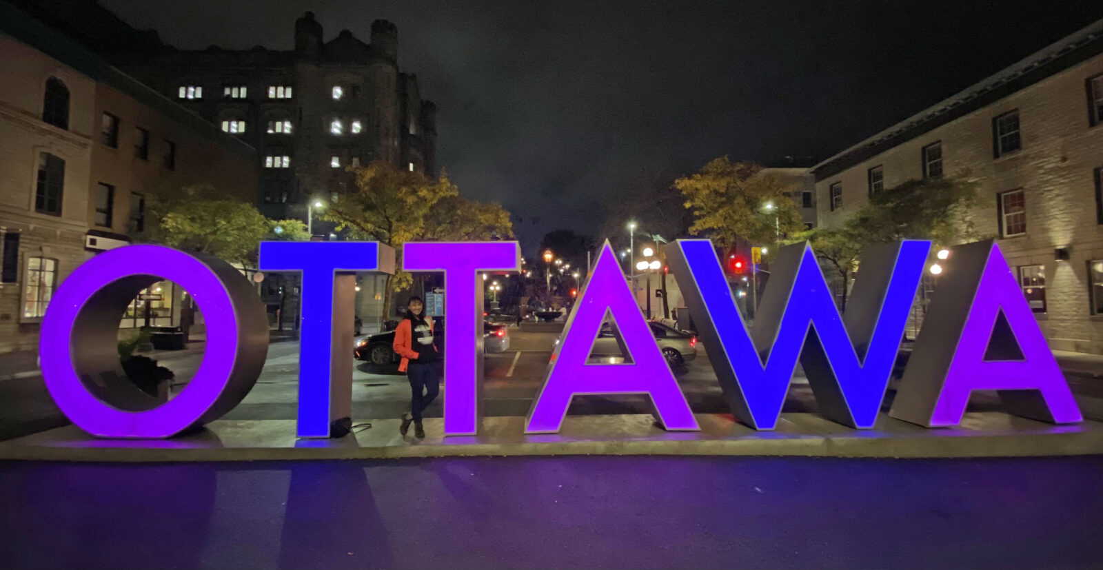 The Ottawa sign in Byward Market lit purple and blue.